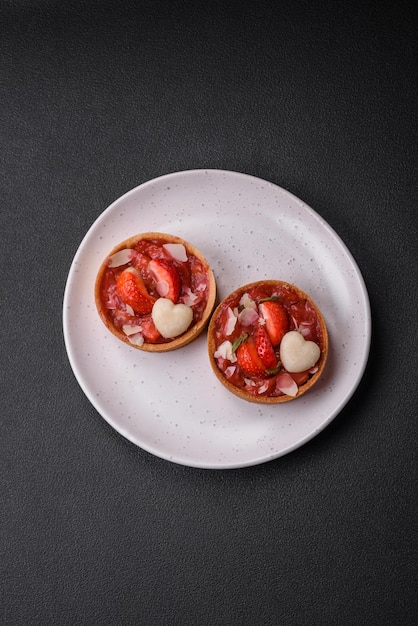 Delicious fresh sweet tartlets with strawberries and coconut flakes