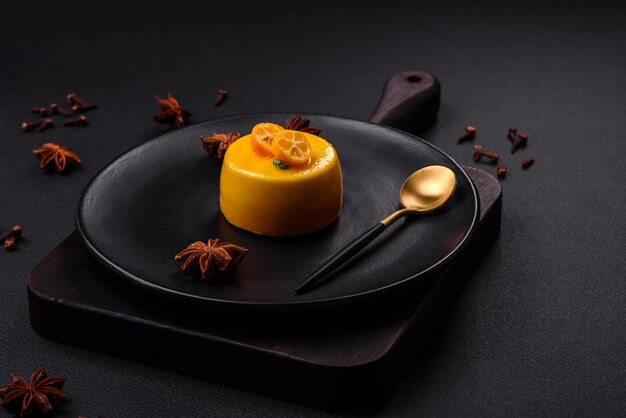 Delicious fresh tartlet with citrus filling and decorated with passion fruit on a black plate