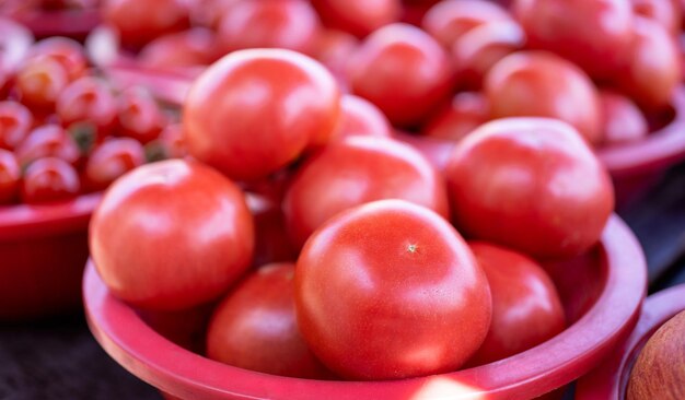 伝統的な市場の午後ソウル韓国収穫コンセプトで赤いプラスチックバスケットのおいしい新鮮なトマト果物野菜食品がクローズアップ