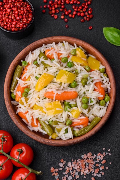 Delicious fresh white boiled rice with vegetables carrots peppers and asparagus beans on a ceramic plate