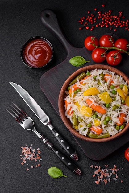 Вкусный свежий белый вареный рис с овощами морковими перцами и спаржевыми бобами на керамической тарелке