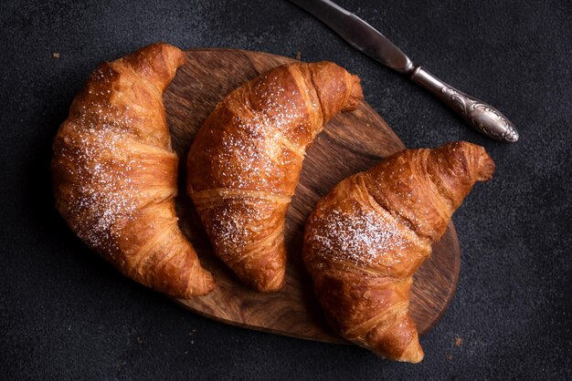 Delicious freshly baked croissant on dark background