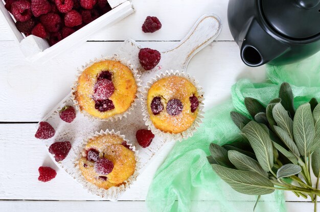 Delicious freshly baked muffins with raspberries, decorated with powdered sugar