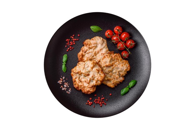 Вкусная жареная куриная отбивная или свиное мясо, обжаренное в панировке с солеными специями и травами на темном бетонном фоне