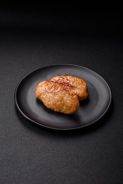 Photo delicious fried cutlets or meatballs with salt spices and herbs on a dark concrete background