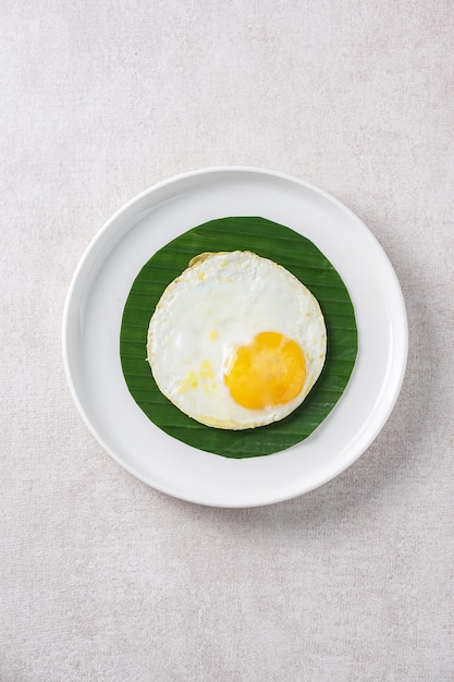 delicious fried egg on leaf and plate