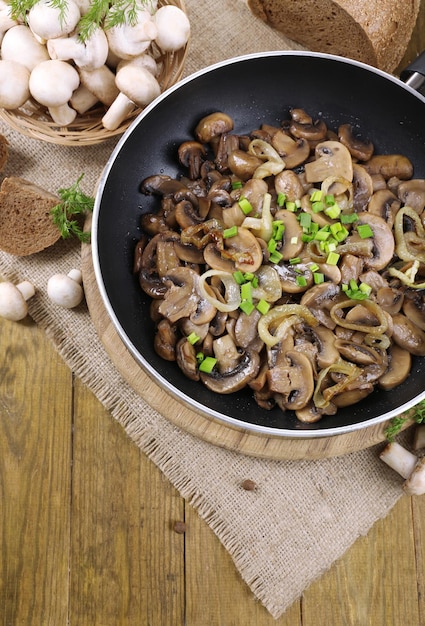 Photo delicious fried mushrooms in pan on table closeup