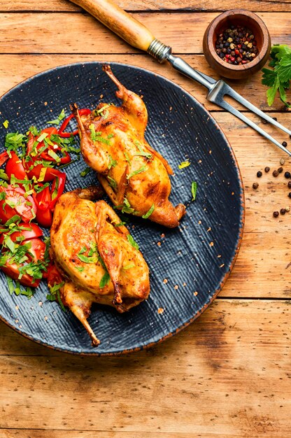 Delicious fried quail and spring vegetable salad on plate.Meat food