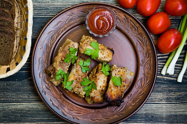 Delicious fried ribs, dressed with honey sauce, decorated with greens and vegetables