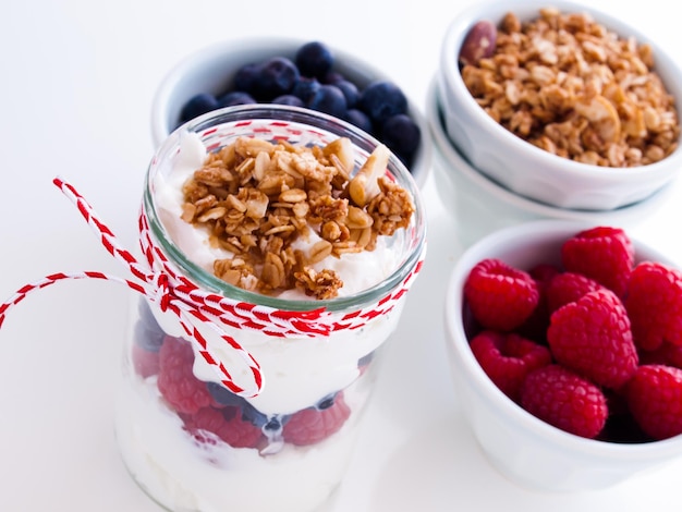 Delicious fruit, greek yogurt and granola parfaits on white background