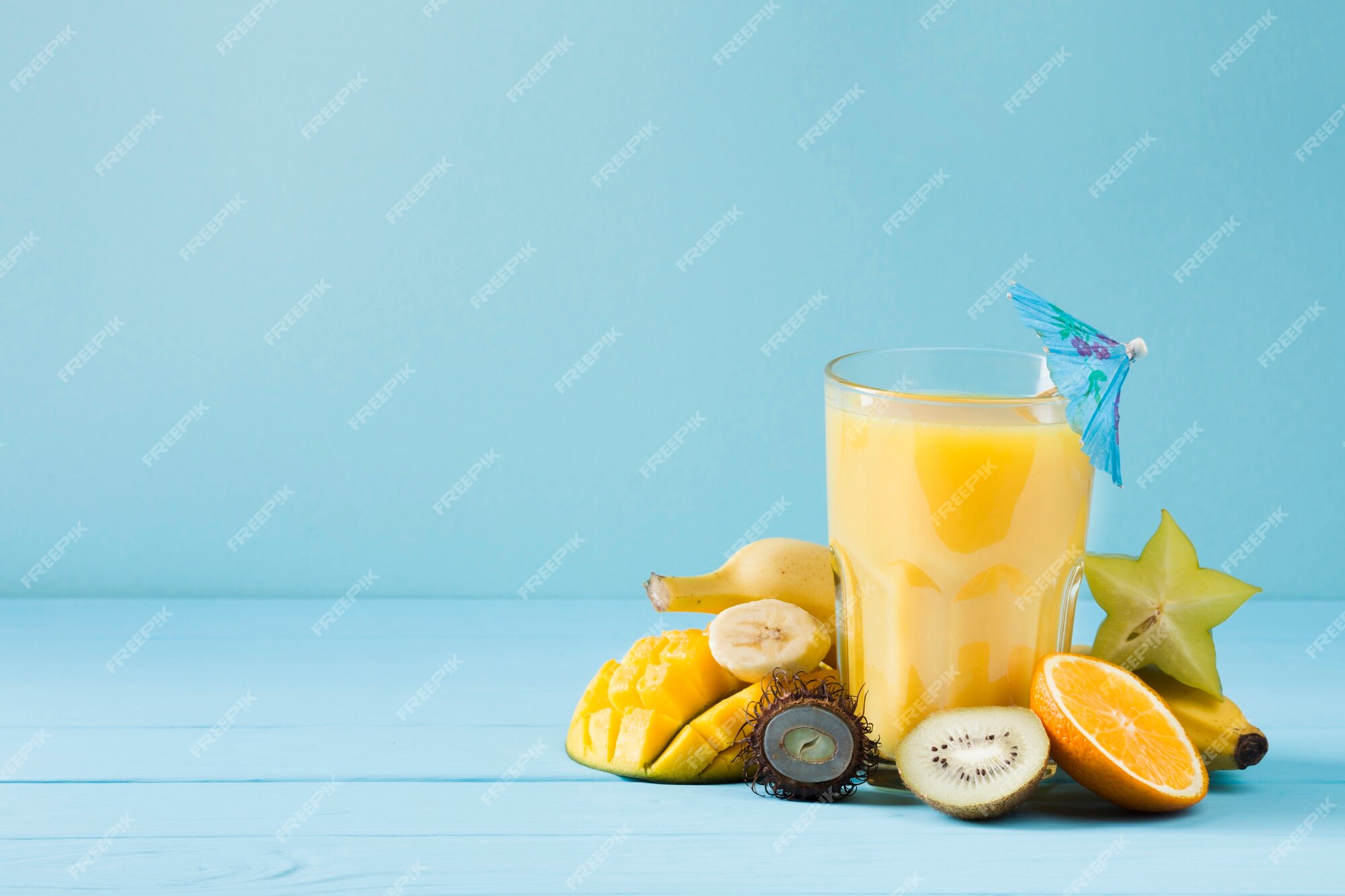 Premium Photo | Delicious fruit juice on blue background