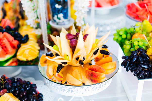 Delicious fruits appetizers. modern sweet table at wedding.