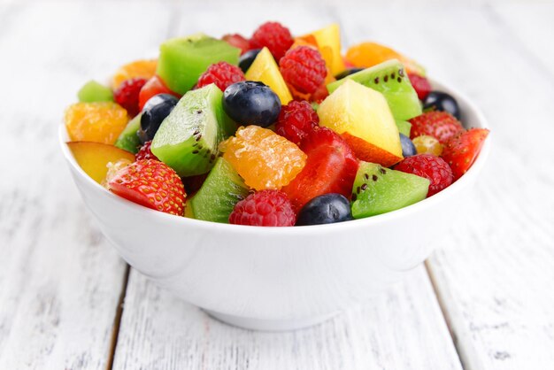 Delicious fruits salad in plate on table closeup