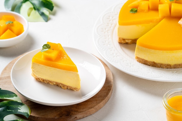 Delicious glazed mango no baked cheese cake with fresh diced mango pulp topping on bright table background