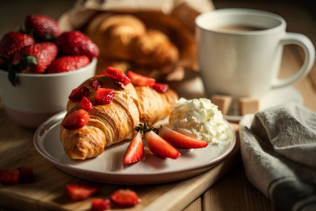 Foto deliziosi croissant dorati ripieni di marmellata di fragole.