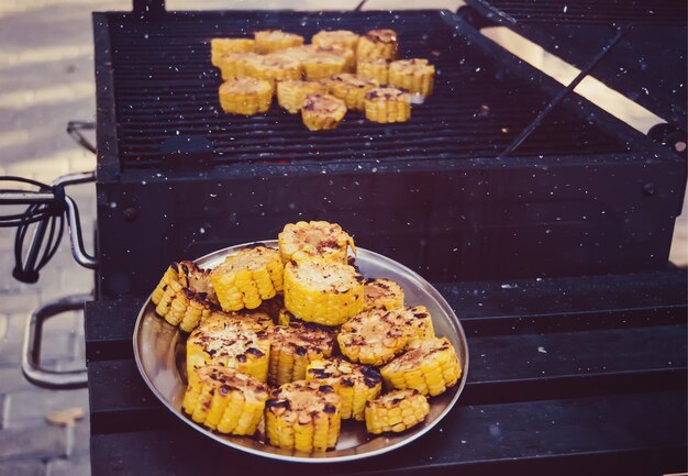 Вкусная золотистая кукуруза на гриле в початках, подаваемая на открытом воздухе