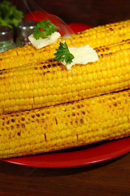 Photo delicious golden grilled corn with butter on table on wooden background