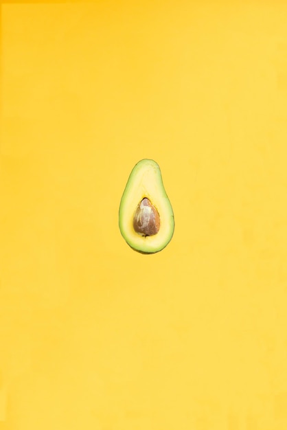 delicious green avocado from the orchard isolated on yellow background