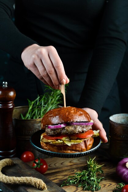 子牛のカツレツ玉ねぎと野菜のおいしい焼きハンバーガー古い暗い背景に