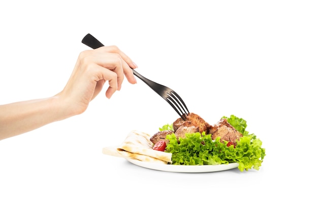 Delicious grilled meat with vegetable on white plate isolated on white background Meat in female hand on the fork