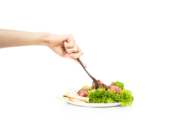 Delicious grilled meat with vegetable on white plate isolated on white background Meat in female hand on the fork