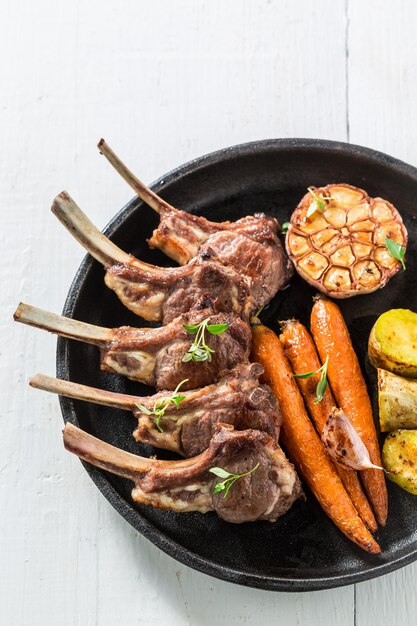 Deliziose costolette di agnello alla griglia su un vecchio tavolo bianco