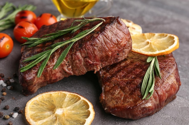 Delicious grilled steaks on grunge background