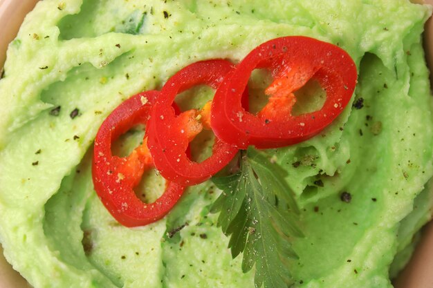 Delicious guacamole with chili pepper and parsley as background top view