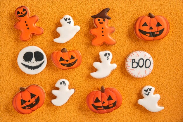 Delicious halloween cookies, Pumpkin and ghosts. Halloween gingerbread cookies on orange background. Homemade cookies.