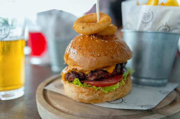 Delicious hamburger served on wooden board on table in pub