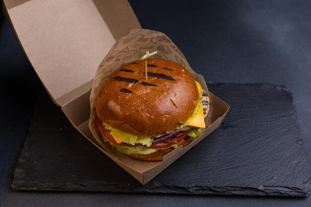 Delicious hamburger with cutlet lettuce tomato onion sauce closeup