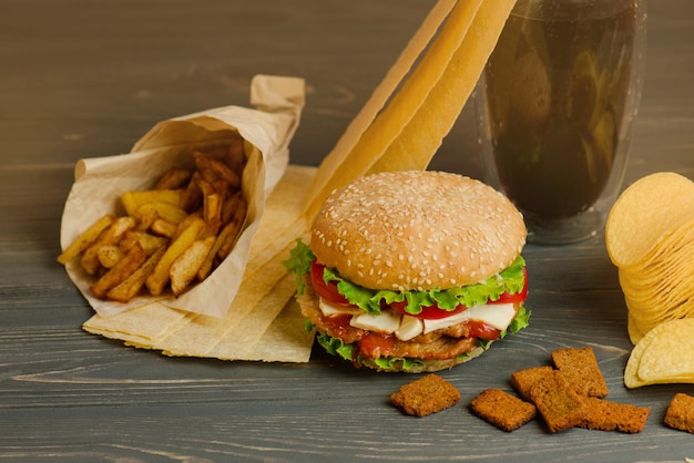 Delicious hamburger with fries snacks and chips Mix of snacks Yummy burger and salty snack including potato chips