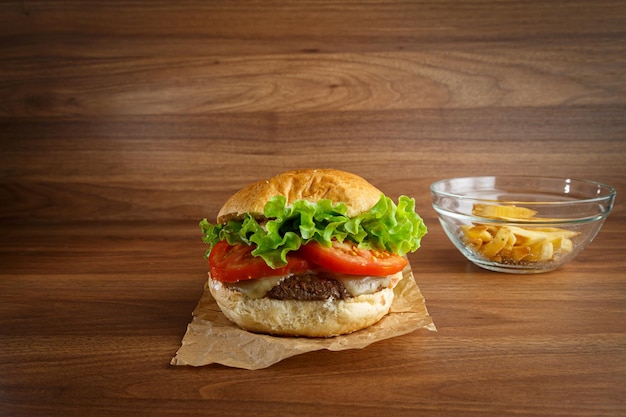 Delicious hamburger on wooden background Burger with tomato lettuce meat and cheese