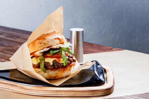 Delicious hamburger on wooden table.