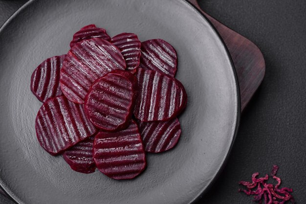 Delicious healthy boiled rubycolored beets sliced on a black plate