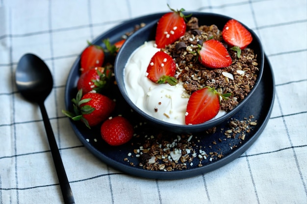 Delicious healthy breakfast or dessert with strawberries white yogurt and chocolate granola Healthly food Strawberry dessert Breakfast bowl