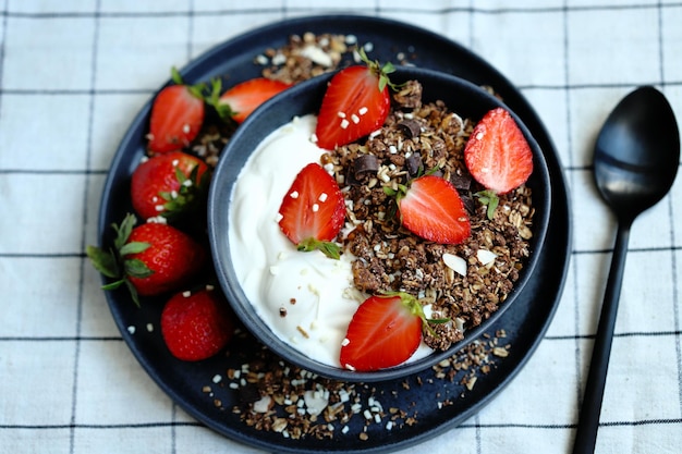 Delicious healthy breakfast or dessert with strawberries white yogurt and chocolate granola Healthly food Strawberry dessert Breakfast bowl