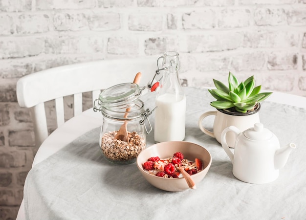 Foto deliziosa colazione sana muesli con frutti di bosco freschi e latte di cocco su uno sfondo chiaro