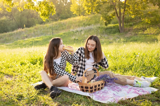 Photo delicious healthy food girls on a picnic in the sun eating baguette fruit from a basket