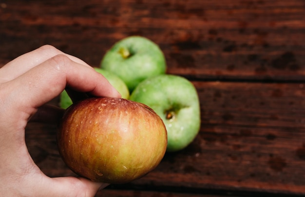 美味しくて健康的な食べ物人間はそれを食べる前に赤いリンゴを手に持っています