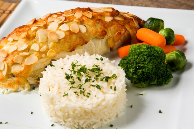 Delicious healthy grilled fish fillet served on a platter with a colorful fresh salad for a tasty seafood dinner.