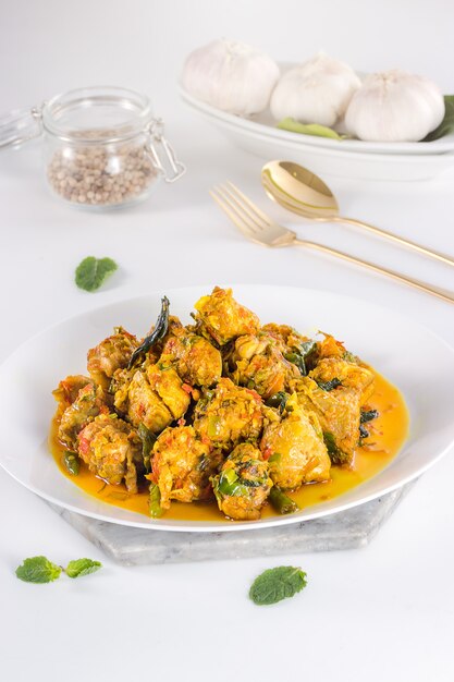 Delicious and healthy Indonesian food in white plate with golden fork and spoon on white background