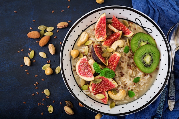 Delicious and healthy oatmeal with figs, nuts, kiwi and seeds. Healthy breakfast. 