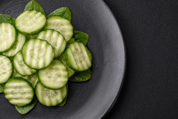 Delicious healthy raw cucumber sliced on a black ceramic plate