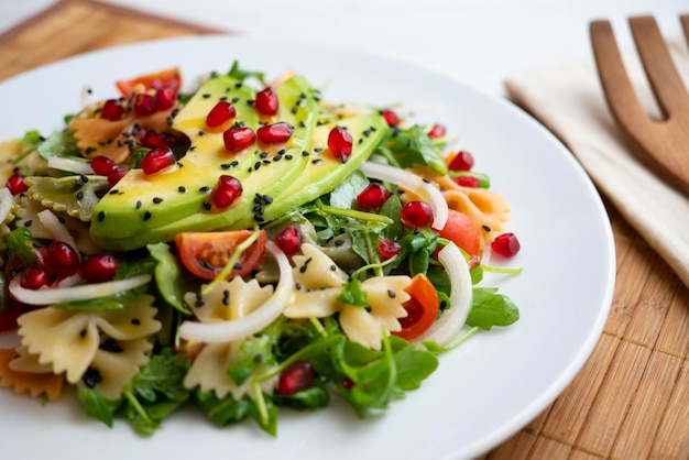 Delicious and healthy salad with pasta bows and avocado