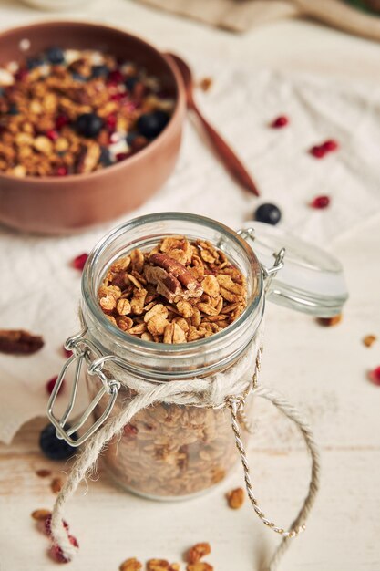 Delicious healthy vegan granola with pecan nuts in a fruity bowl with yogurt on a white table