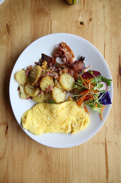 A delicious home style breakfast with crispy bacon, eggs omelette