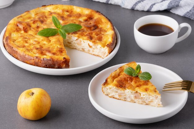 Вкусный домашний яблочный пирог, подаваемый с кофе и украшенный листьями мяты на уютной кухне