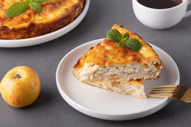 Вкусный домашний яблочный пирог, подаваемый с кофе и украшенный листьями мяты на уютной кухне