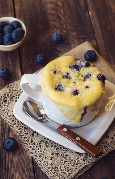 전자레인지 컵으로 조리한 신선한 딸기를 곁들인 맛있는 홈메이드 블루베리 머핀 머핀 케이크